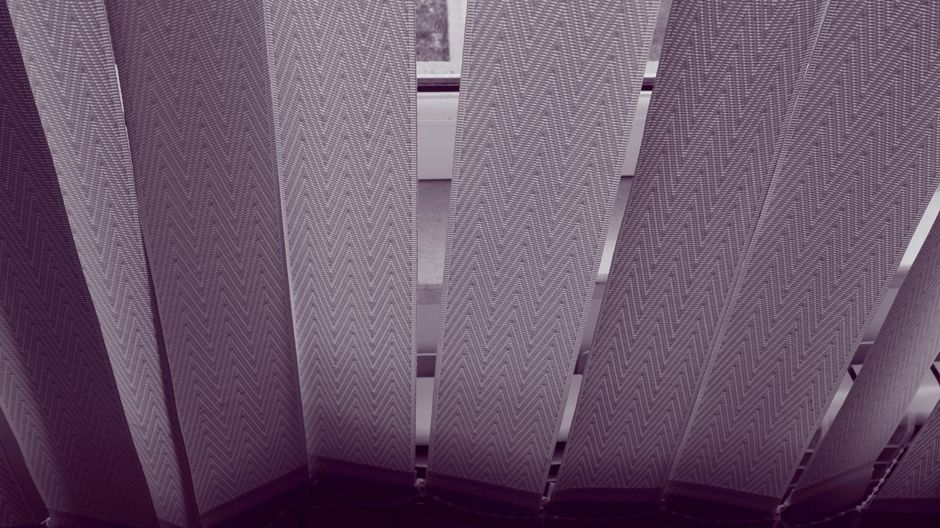 Close-up of geometric patterned vertical blinds in a modern interior setting.